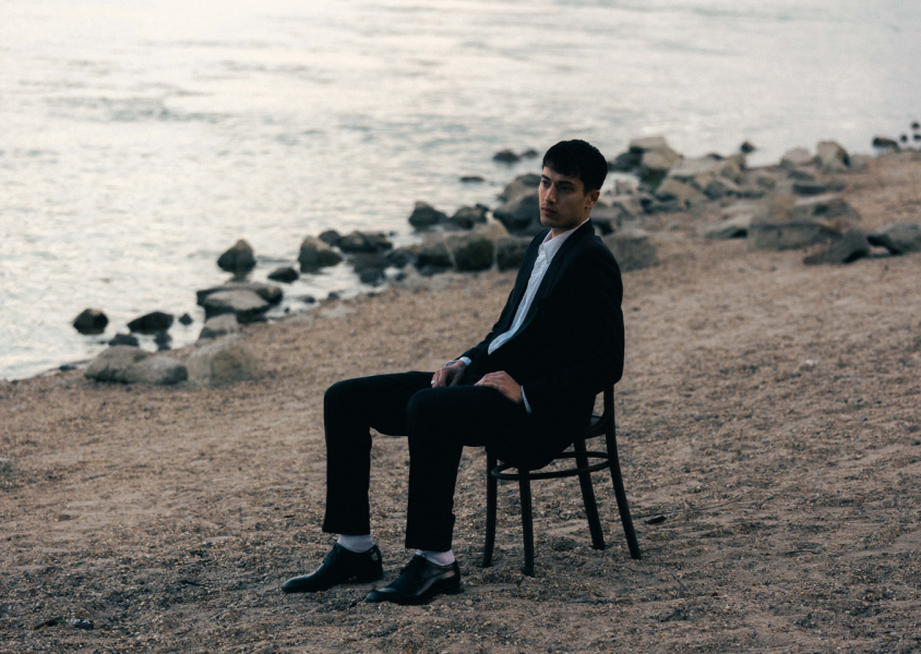 Artist Eden sitting on chair at beachx